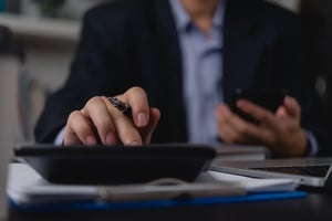businessman-hands-using-a-smartphone-and-calculato-2025-03-09-16-24-35-utc